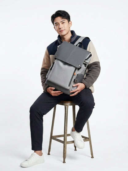 Grey Japanese style tooling backpack placed on a hand and set on a wooden chair