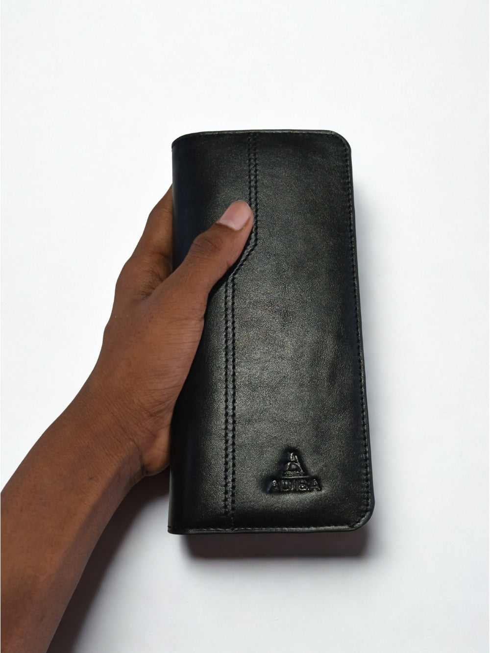 Hand holding Adiba Leather black men's long clutch wallet vertical orientation