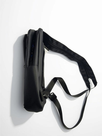 Side view of Arctic Hunter black crossbody sling bag showing slim profile and zipper compartments