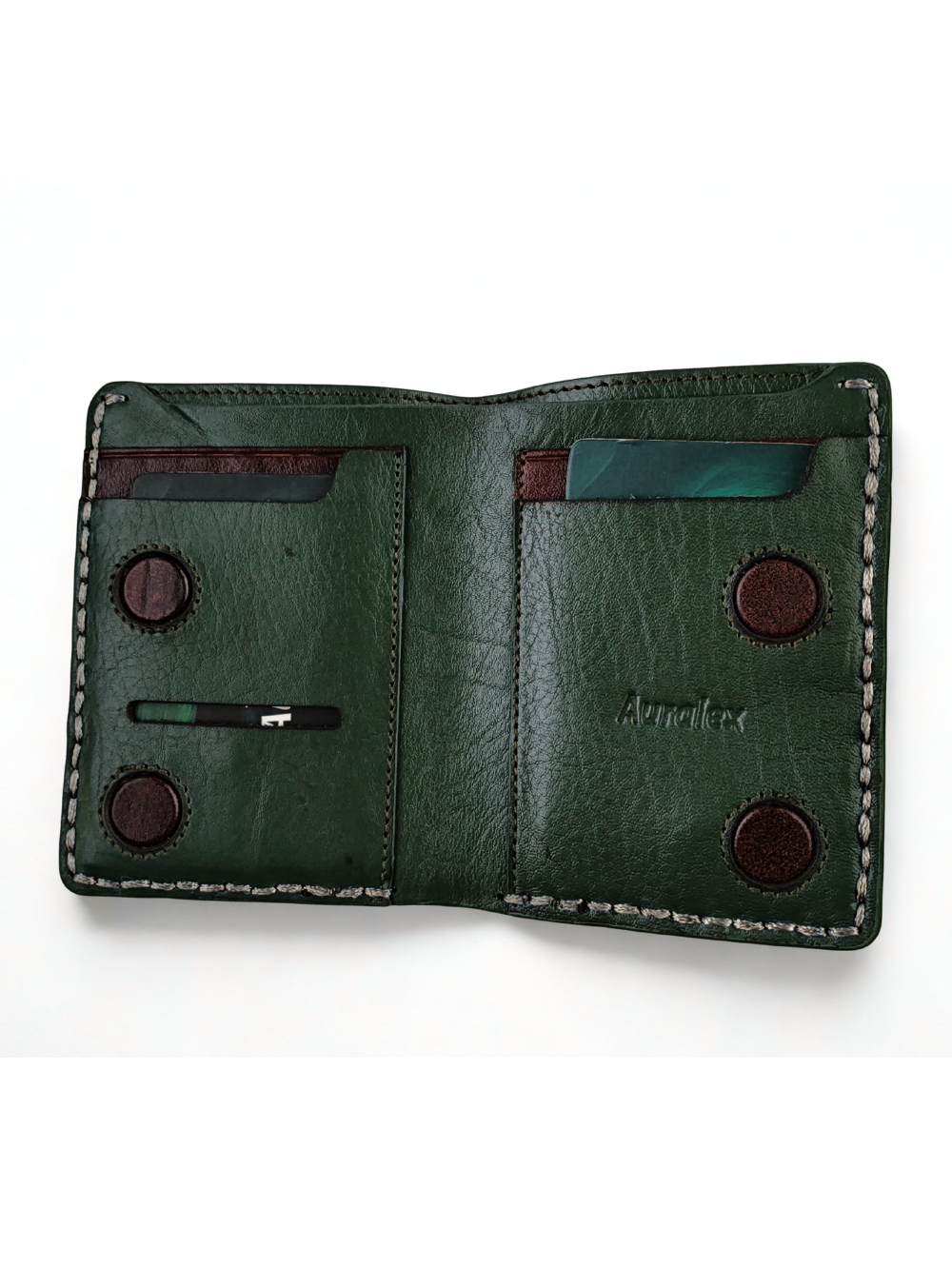 Open interior view of dark green leather vertical wallet showing card slots and circular magnetic closures
