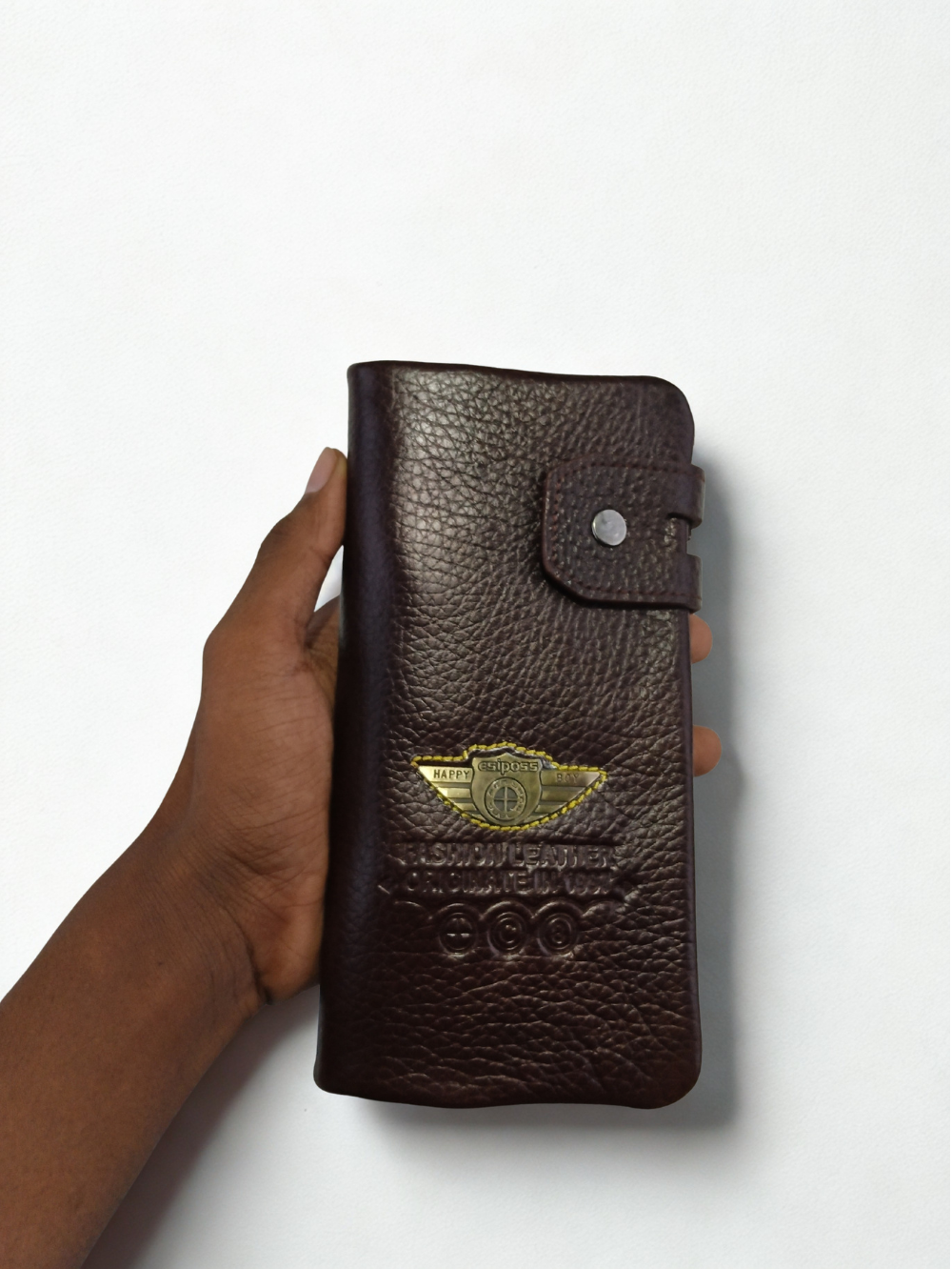 Hand holding dark brown Esiposs pebbled leather long men's trifold clutch wallet